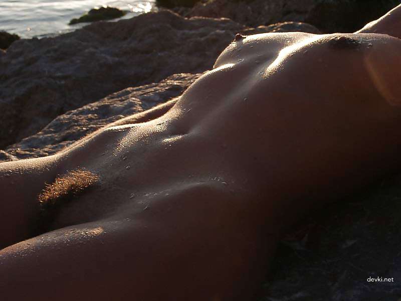 Naked girl sunbathing at the beach - Explicit and daring seaside relaxation