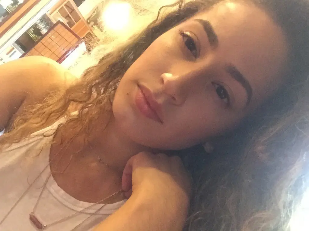 Curly-haired selfie girl flaunts her breasts in explicit photo