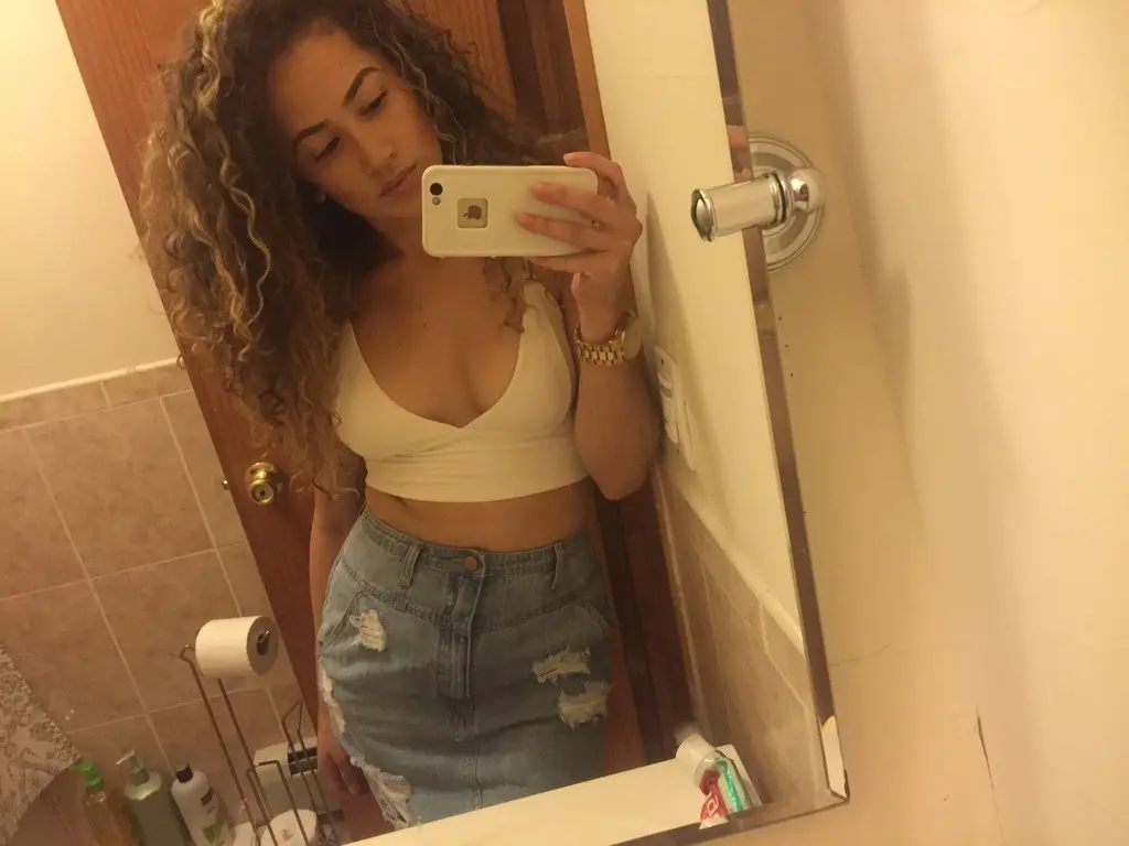 Curly-haired selfie girl flaunts her breasts in explicit photo