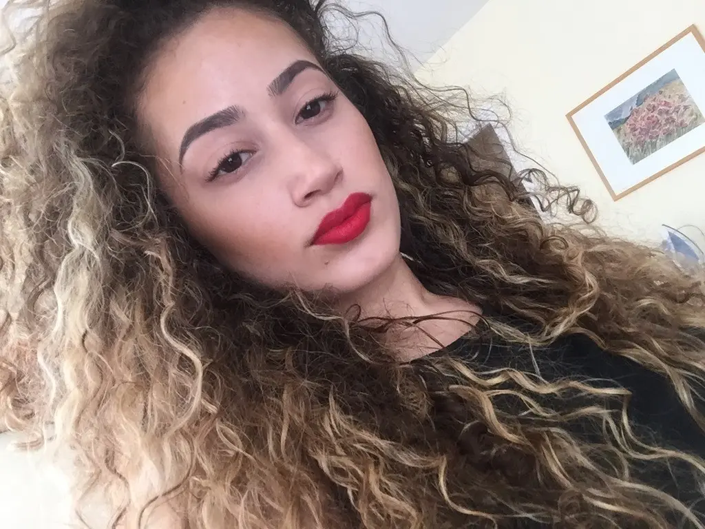 Curly-haired selfie girl flaunts her breasts in explicit photo