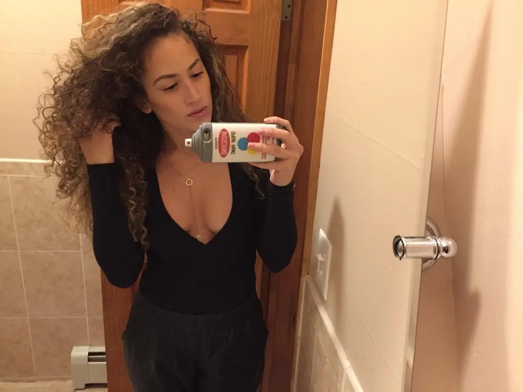 Curly-haired selfie girl flaunts her breasts in explicit photo