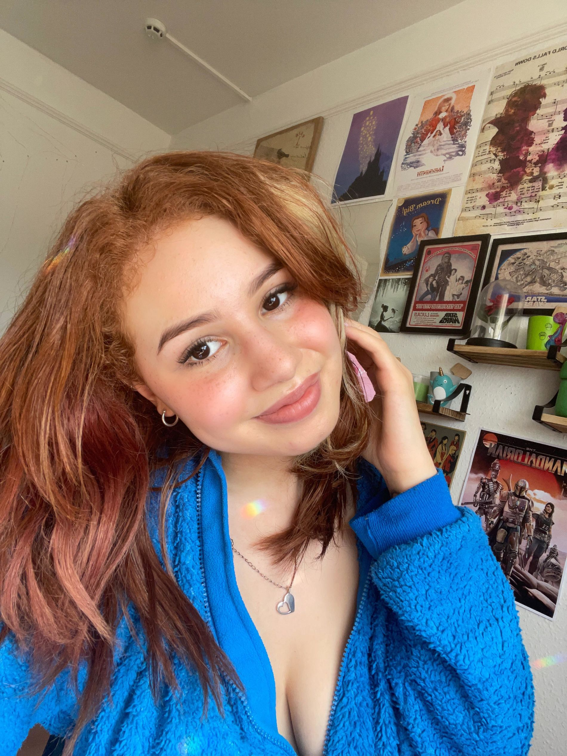 Naked redhead posing on chair, smiling sweetly, taking nude selfie