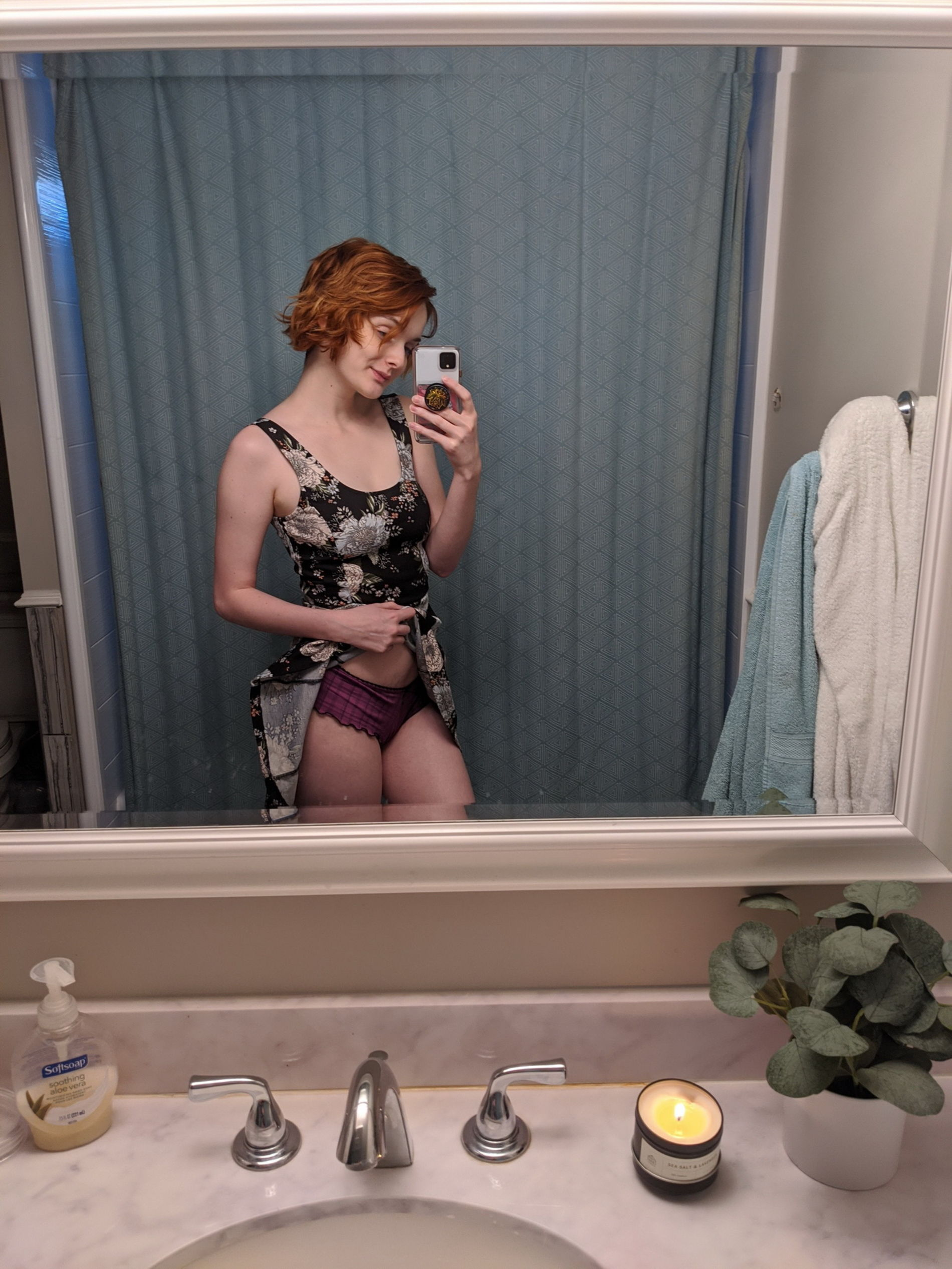 Seductive redhead babe takes sultry selfie in dimly lit room mirror