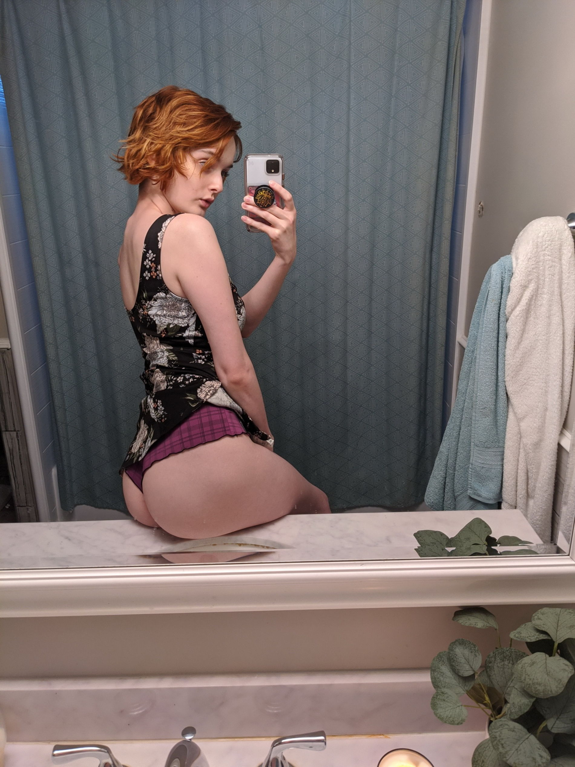 Seductive redhead babe takes sultry selfie in dimly lit room mirror