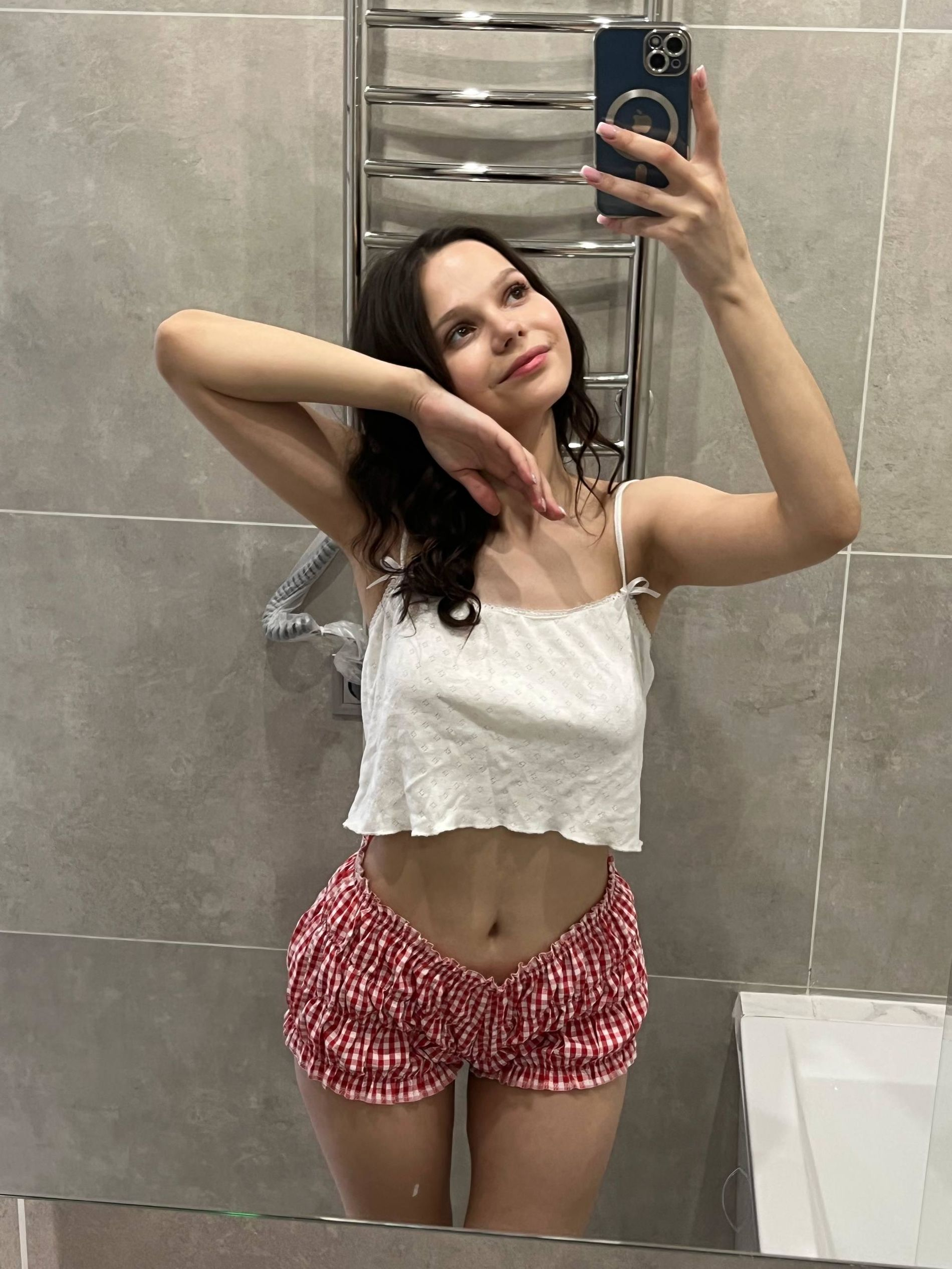 Young woman with large areolas frequently poses nude in various outfits